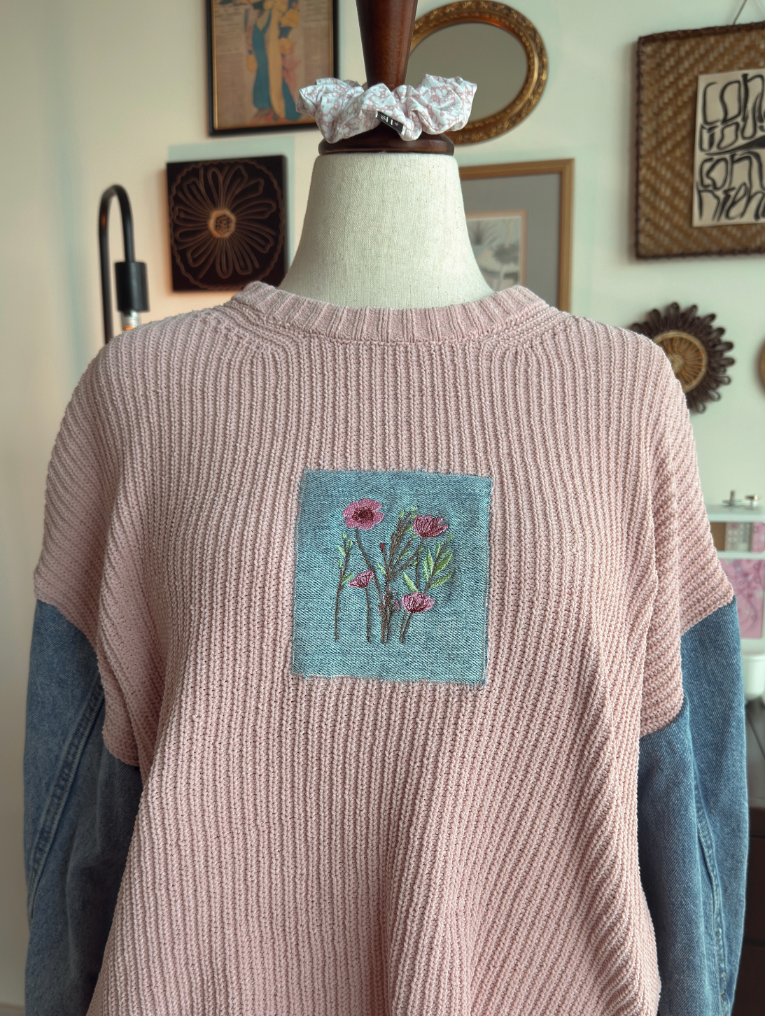 Pink sweater with floral patch on a mannequin with a matching scrunchy